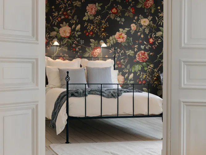 Red flowers and green leaves on dark vintage wallpaper