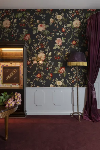 Red flowers and green leaves on dark vintage wallpaper